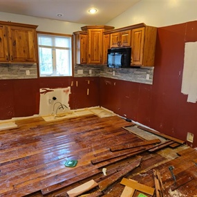Removal of buckled hardwood flooring caused by prolonged water exposure in a vacant Medford home